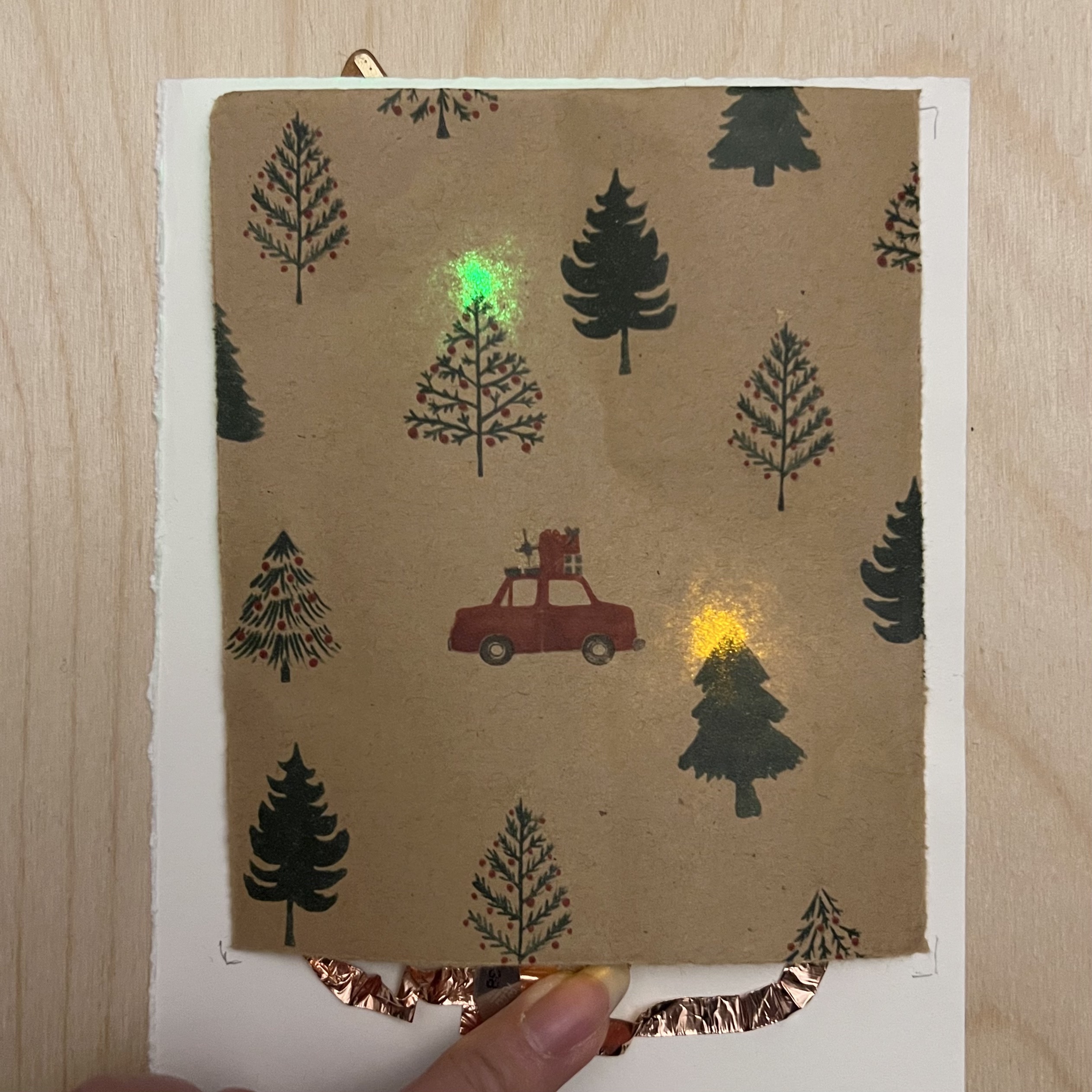 Wrapping paper lit up behind trees and car