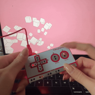 Using the Makey Makey arrow keys and space bar to move around the collection of boxes